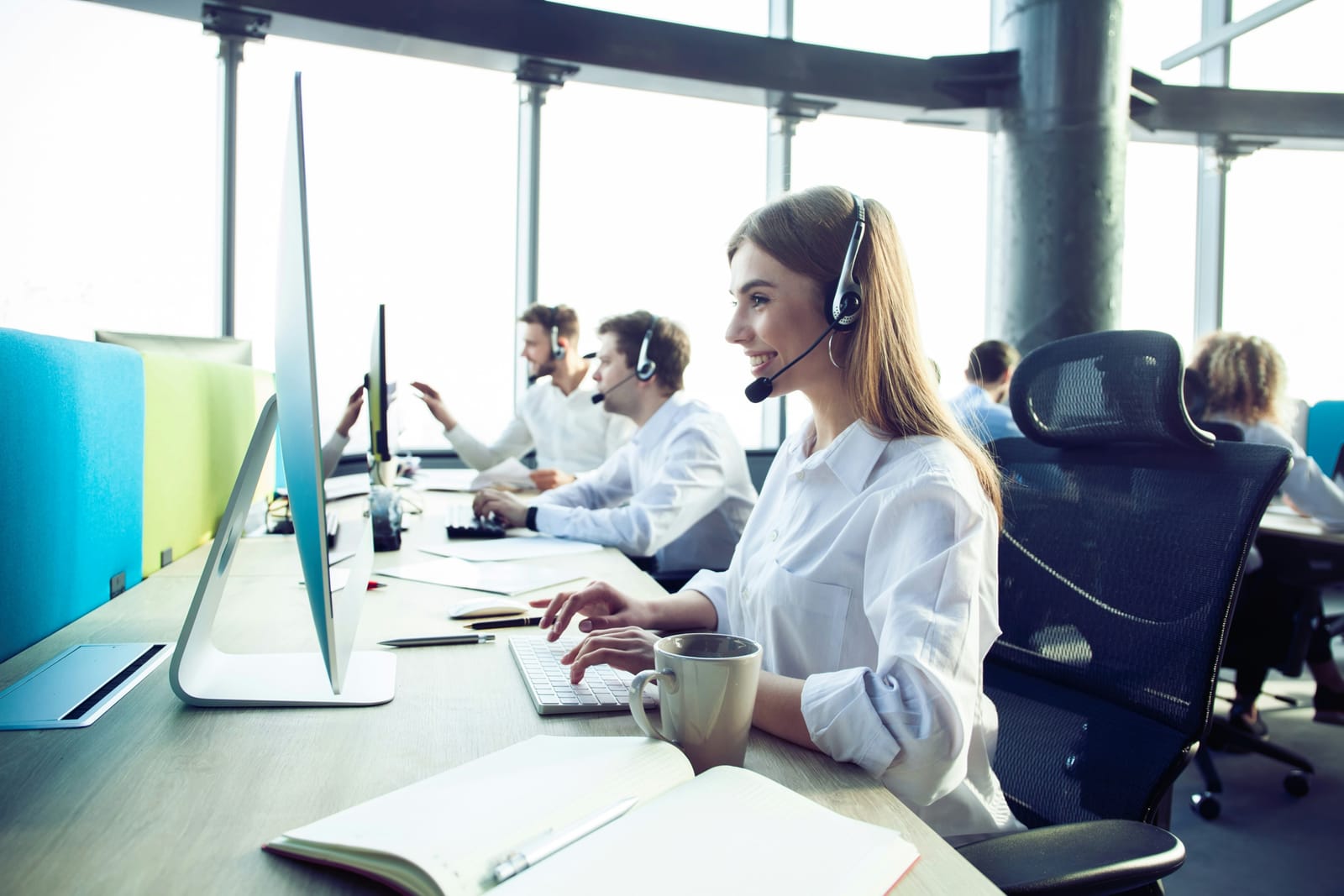 Service desk analysts working at their monitors wearing headsets